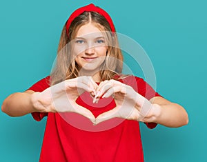 Beautiful young caucasian girl wearing casual red t shirt smiling in love doing heart symbol shape with hands