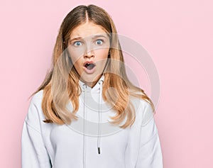 Beautiful young caucasian girl wearing casual sweatshirt afraid and shocked with surprise expression, fear and excited face