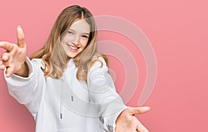 Beautiful young caucasian girl wearing casual sweatshirt looking at the camera smiling with open arms for hug