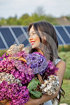 Beautiful young caucasian woman with bouquets of lilac flowers