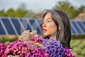 Beautiful young caucasian woman with bouquets of lilac flowers