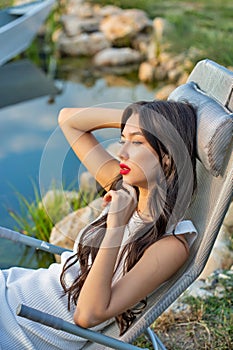 Beautiful young caucasian woman lying on a sun lounger