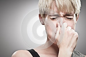 Beautiful Young Caucasian Woman Plugging Her Nose photo