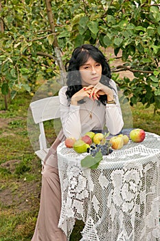 Beautiful young caucasian woman sitting in an orchard