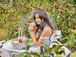 Beautiful young caucasian woman sitting in an orchard