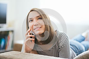 Beautiful young caucasian woman on sofa using cell phone