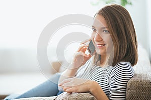 Beautiful young caucasian woman on sofa using cell phone