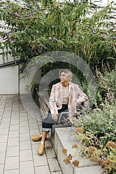 Beautiful young caucasian woman spends her leisure time sitting in park on warm spring day.