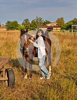 Beautiful young caucasian woman standing near the horse