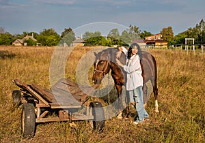 Beautiful young caucasian woman standing near the horse