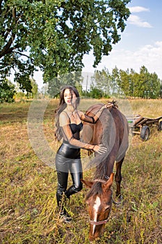 Beautiful young caucasian woman standing near the horse