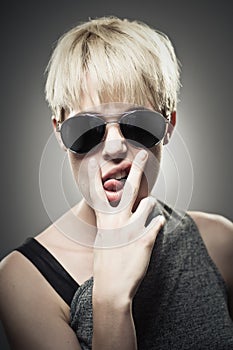 Beautiful Young Caucasian Woman Wearing Aviator And Making A Rude Gesture