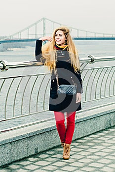 Beautiful young cheerful blonde on the winter promenade