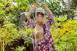 Beautiful young cheerful fashionable woman having fun at tropical background