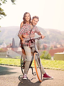 Beautiful young couple on a bicycle smiling