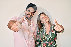 Beautiful young couple of boyfriend and girlfriend together approving doing positive gesture with hand, thumbs up smiling and