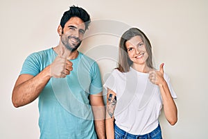 Beautiful young couple of boyfriend and girlfriend together doing happy thumbs up gesture with hand