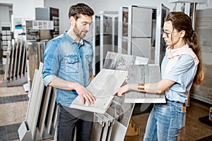 Couple choosing ceramic tiles in the shop photo