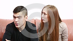 Beautiful young couple conflict sitting on a couch argue unhappy