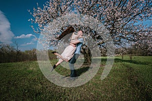 Beautiful young couple dancing and having fun on blue sky background