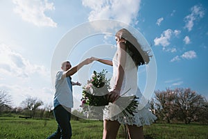 Beautiful young couple dancing and having fun on blue sky background