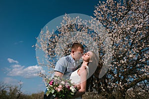 Beautiful young couple dancing and having fun on blue sky background