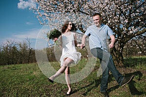 Beautiful young couple dancing and having fun on blue sky background