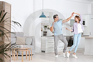 Beautiful young couple dancing in kitchen