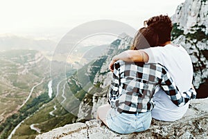 Beautiful young couple enjoying nature at mountain peak.