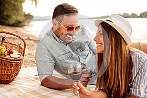 Beautiful young couple enjoying picnic on a beach