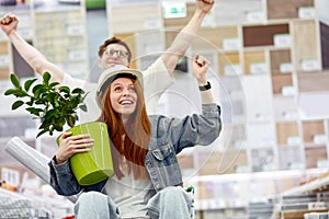 Beautiful young couple having fun while choosing things for home in the market