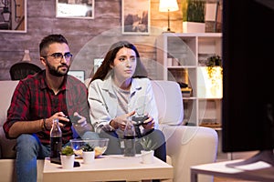 Beautiful young couple having fun playing video games