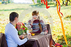 Beautiful Young Couple Having Picnic in autumn Park. Happy Family Outdoor. Smiling Man and Woman relaxing in Park. Relationships.