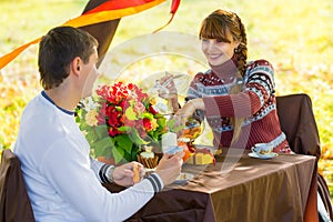 Beautiful Young Couple Having Picnic in autumn Park. Happy Family Outdoor. Smiling Man and Woman relaxing in Park. Relationships