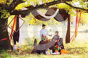 Beautiful Young Couple Having Picnic in autumn Park. Happy Family Outdoor. Smiling Man and Woman relaxing in Park. Relationships.