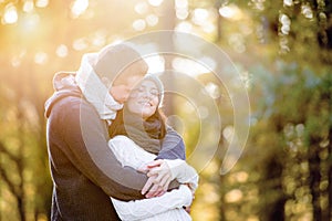 Beautiful young couple hugging and kissing. Sunny autumn nature.