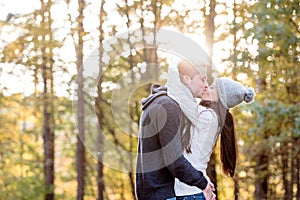 Beautiful young couple hugging and kissing. Sunny autumn nature.