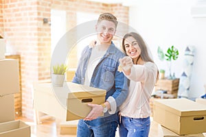 Beautiful young couple hugging in love and showing keys of new house, smiling happy moving to a new apartment