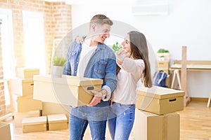 Beautiful young couple hugging in love and showing keys of new house, smiling happy moving to a new apartment