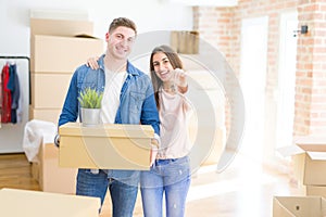 Beautiful young couple hugging in love and showing keys of new house, smiling happy moving to a new apartment