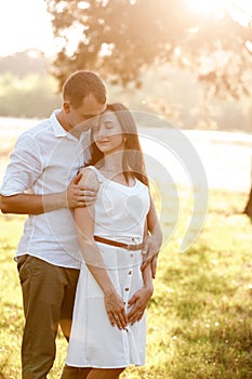 Beautiful young couple are hugging in the summer park. stylish man and woman having fun outdoors. family day concept. copy space