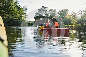 Beautiful young couple kayaking on lake