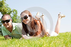 Beautiful young Couple lie down on grass