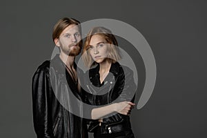 Beautiful young couple with long hair in black leather jackets