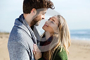 Beautiful young couple in love in a cold winter on the beach.