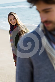 Beautiful young couple in love in a cold winter on the beach.