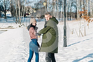 Beautiful young couple in love walks in the park on a clear sunny winter day