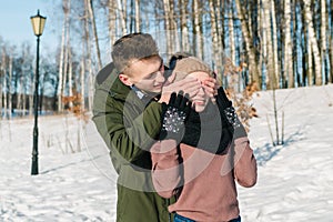 Beautiful young couple in love walks the park on a clear sunny winter day.