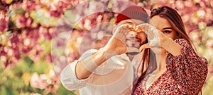 Beautiful young couple making heart sign with hands, smiling. Celebrating Saint Valentine's Day. Heart, hands