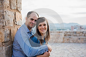 Beautiful young couple near the ancient walls of the old castle